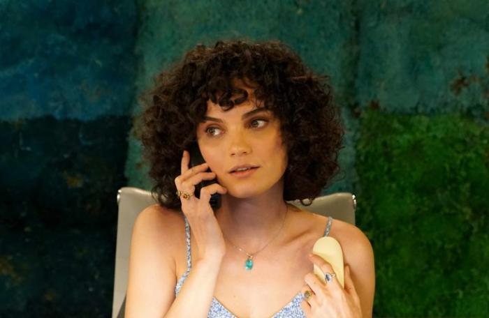 Nazlı Senem Ünal are părul scurt, creț și ține telefonul la urechea dreaptă