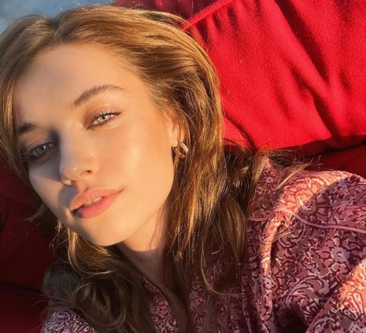 Afra Saraçoğlu poartă părul lung desprins și buzele întredeschise