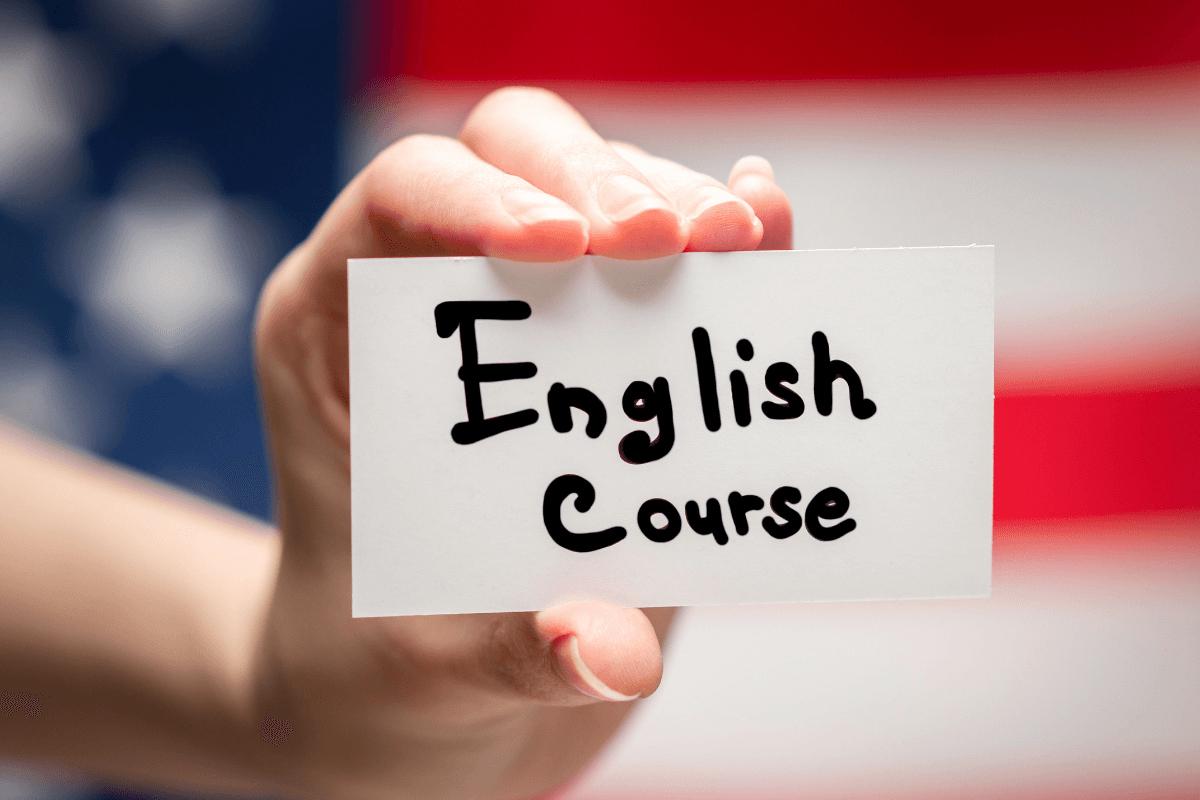 mână care ține un card pe care scrie english course