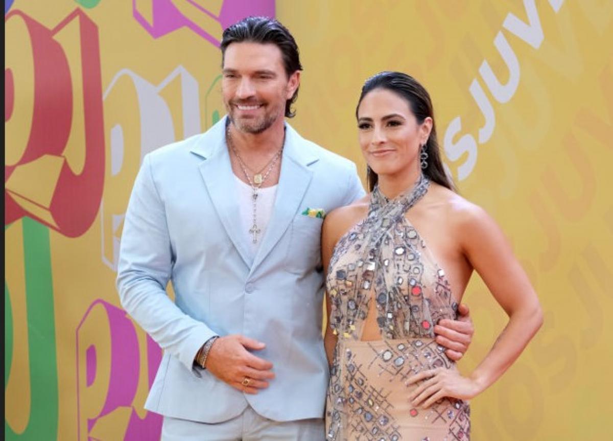 Julián Gil poartă un costum și stă lângă Valeria Marín