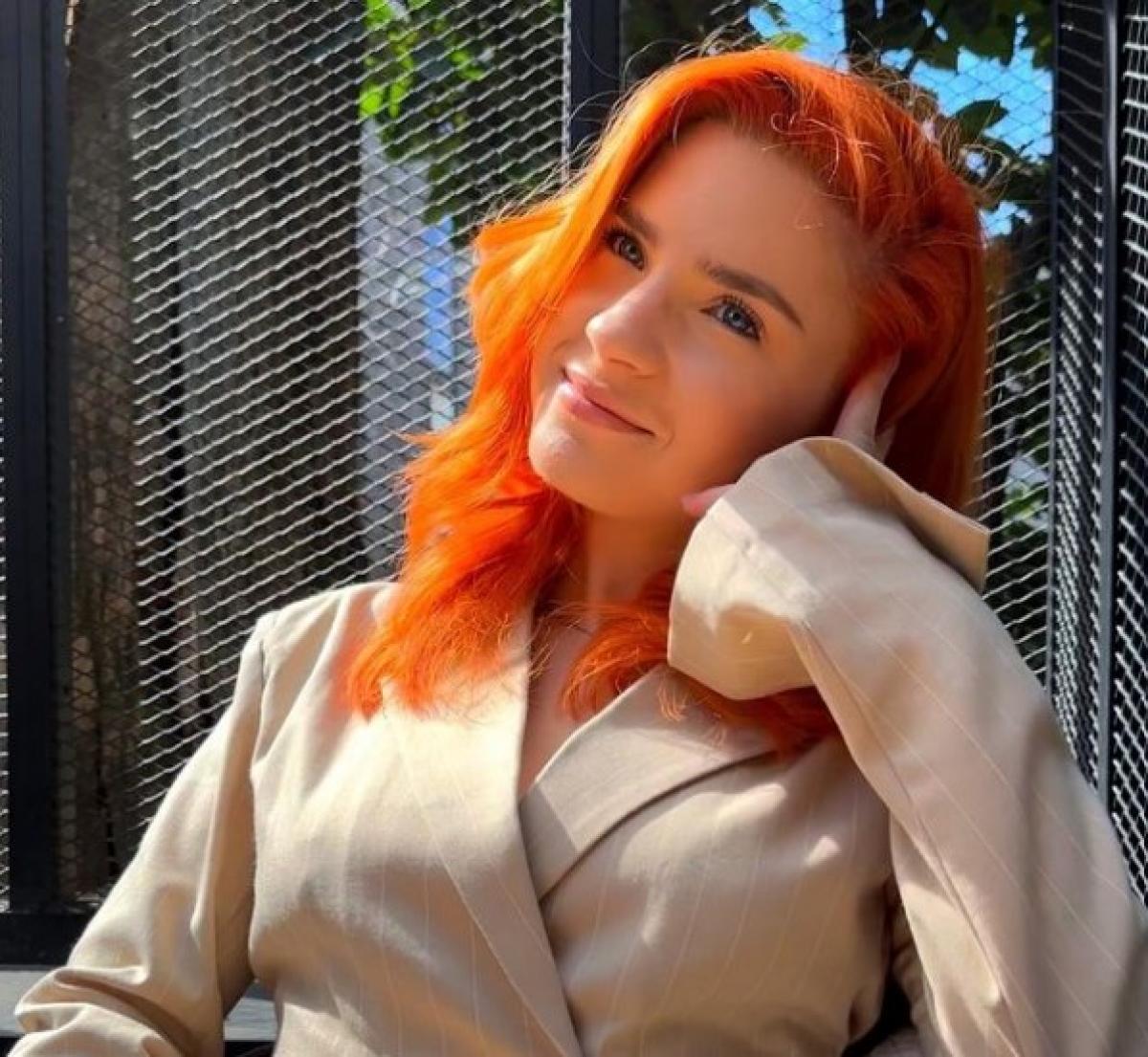 Cristina Ciobănașu poartă un palton maro și păr portocaliu