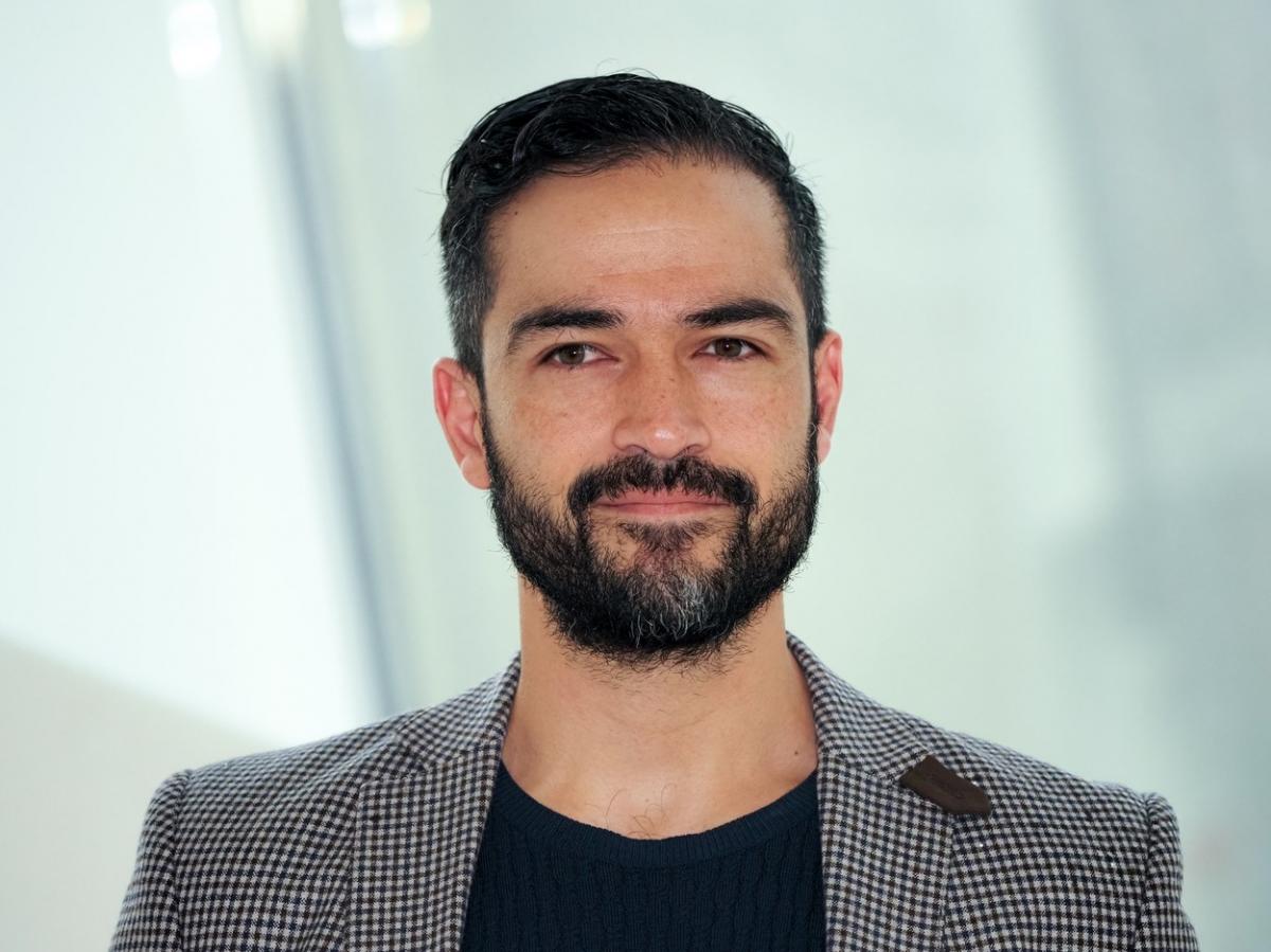 Alfonso Herrera poartă un tricou negru și un sacou gri