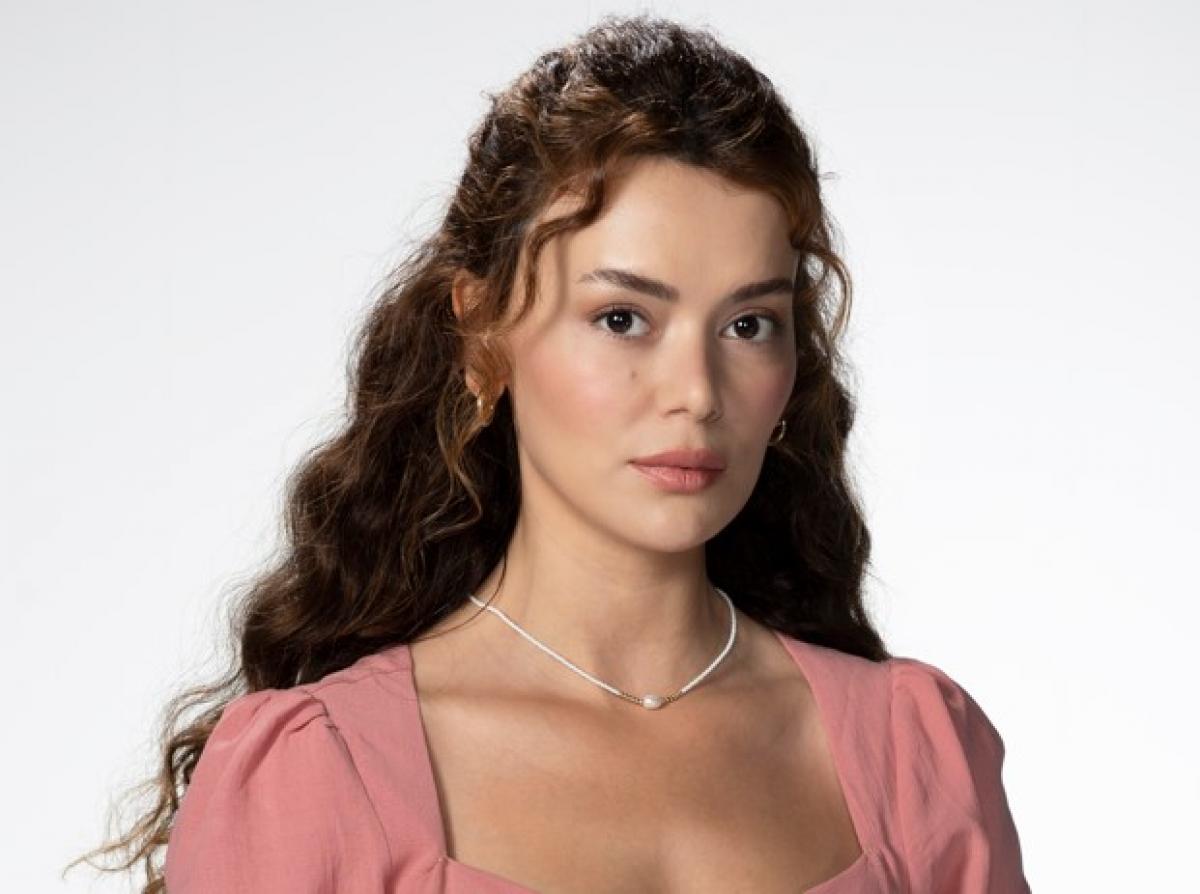 Seray Kaya poartă o rochie roz și părul lung, desprins, ondulat