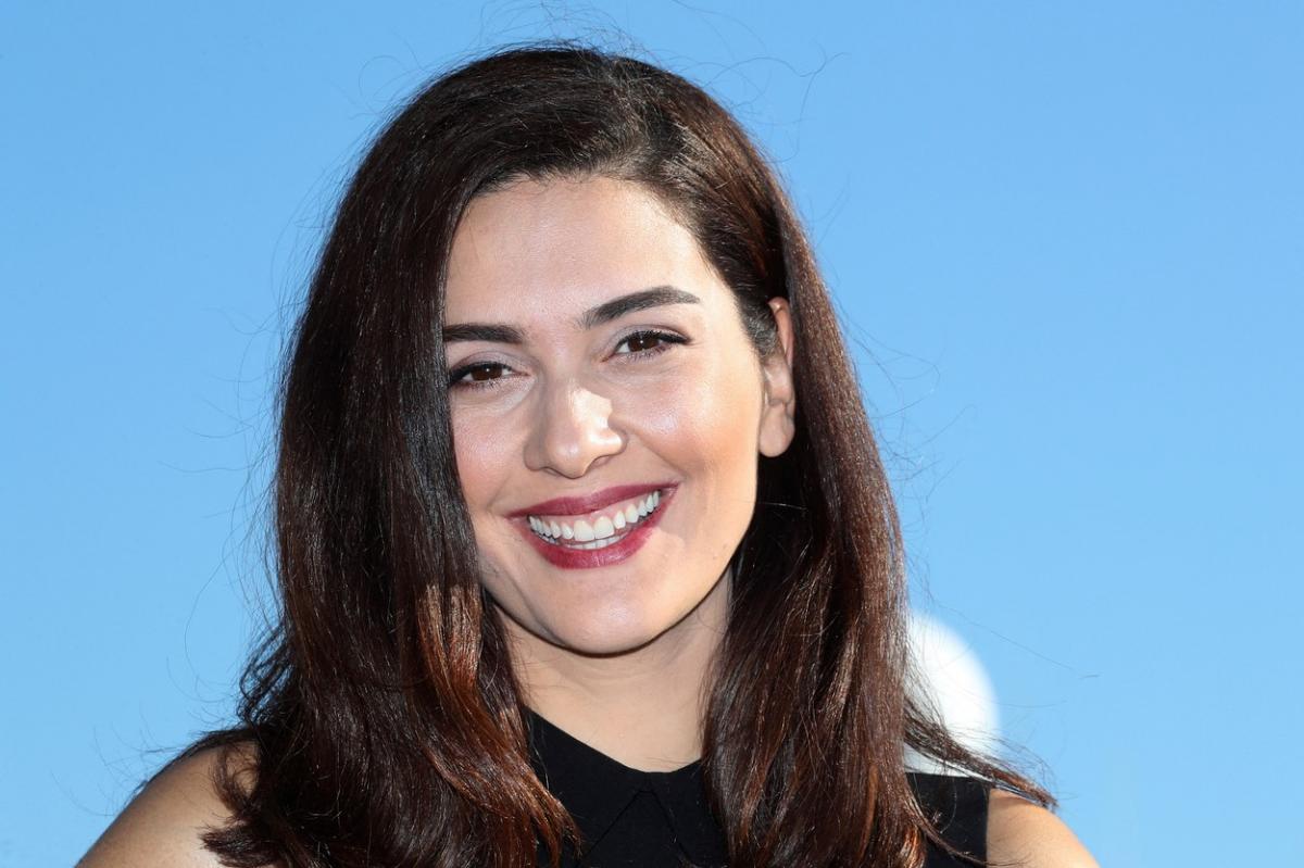 Bergüzar Korel poartă o rochie neagră fără mâneci și are părul desprins