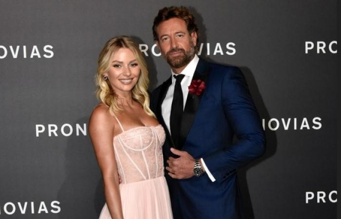 Irina Baeva poartă o rochie roz pal și stă lângă Gabriel Soto care poartă un costum închis la culoare
