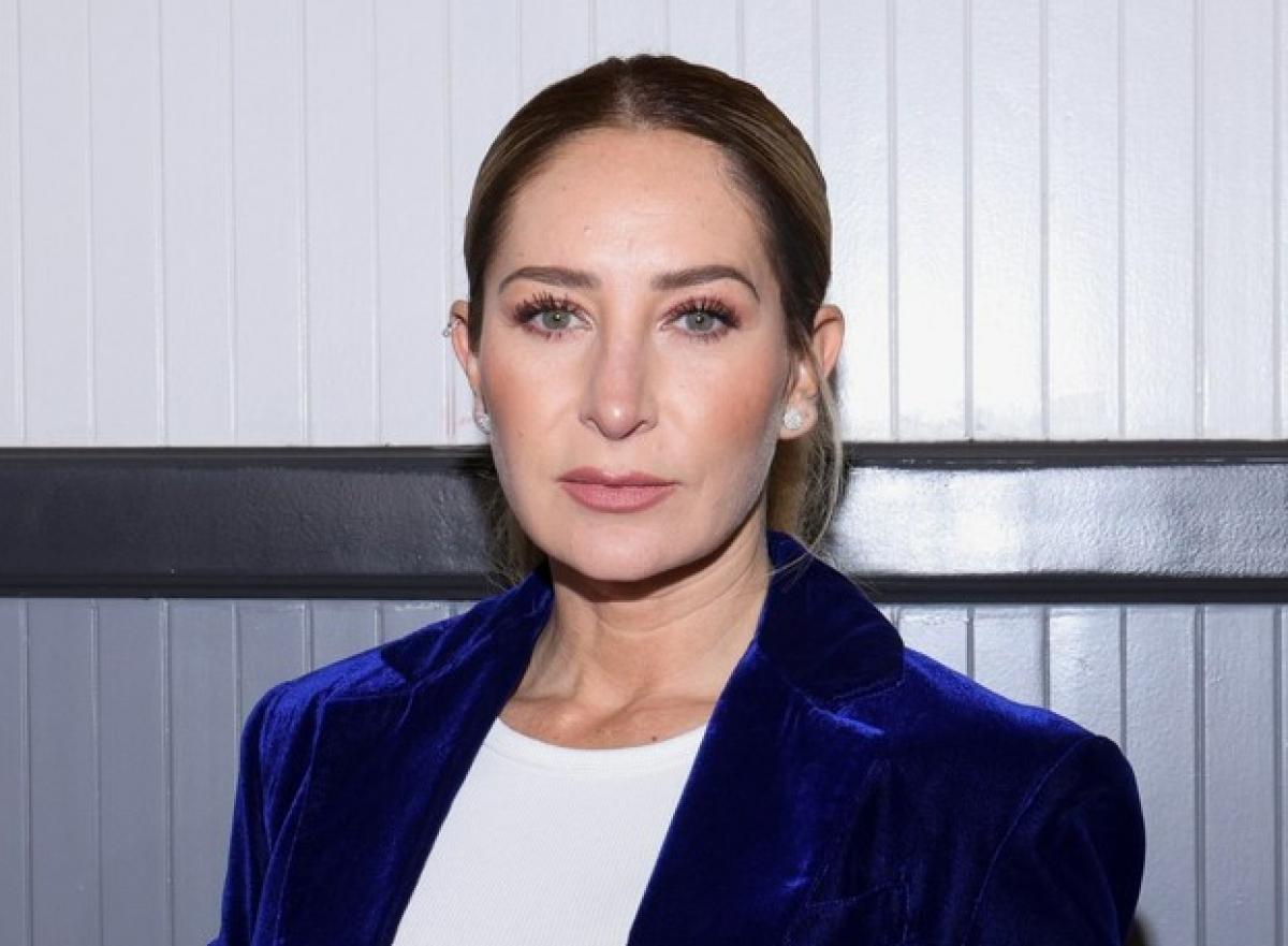 Geraldine Bazán poartă un tricou alb și un sacou albastru închis