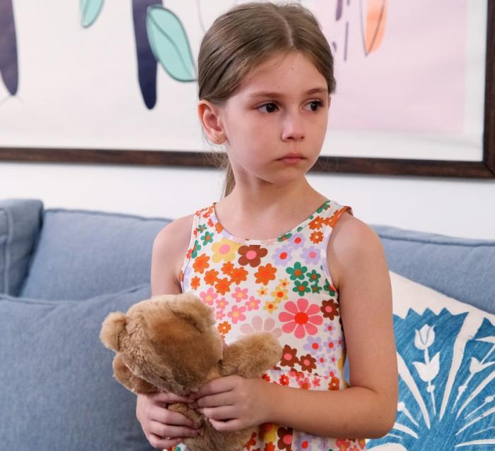 Azra Aksu poartă o rochie cu flori fără mâneci și are părul prins la spate