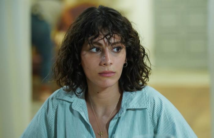 Tuğçe Açıkgöz poartă o cămașă albastră și are părul scurt, ondulat