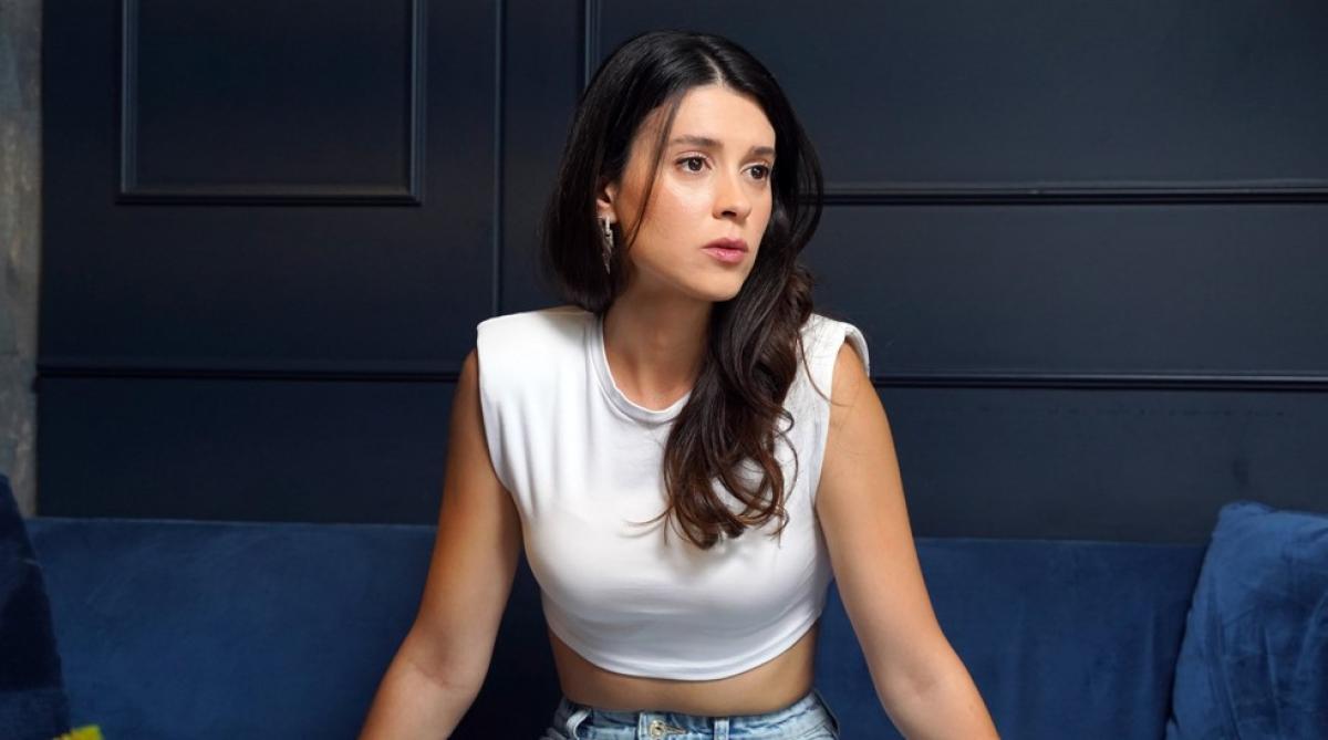 Buçe Buse Kahraman poartă un tricou alb și blugi și părul desprins