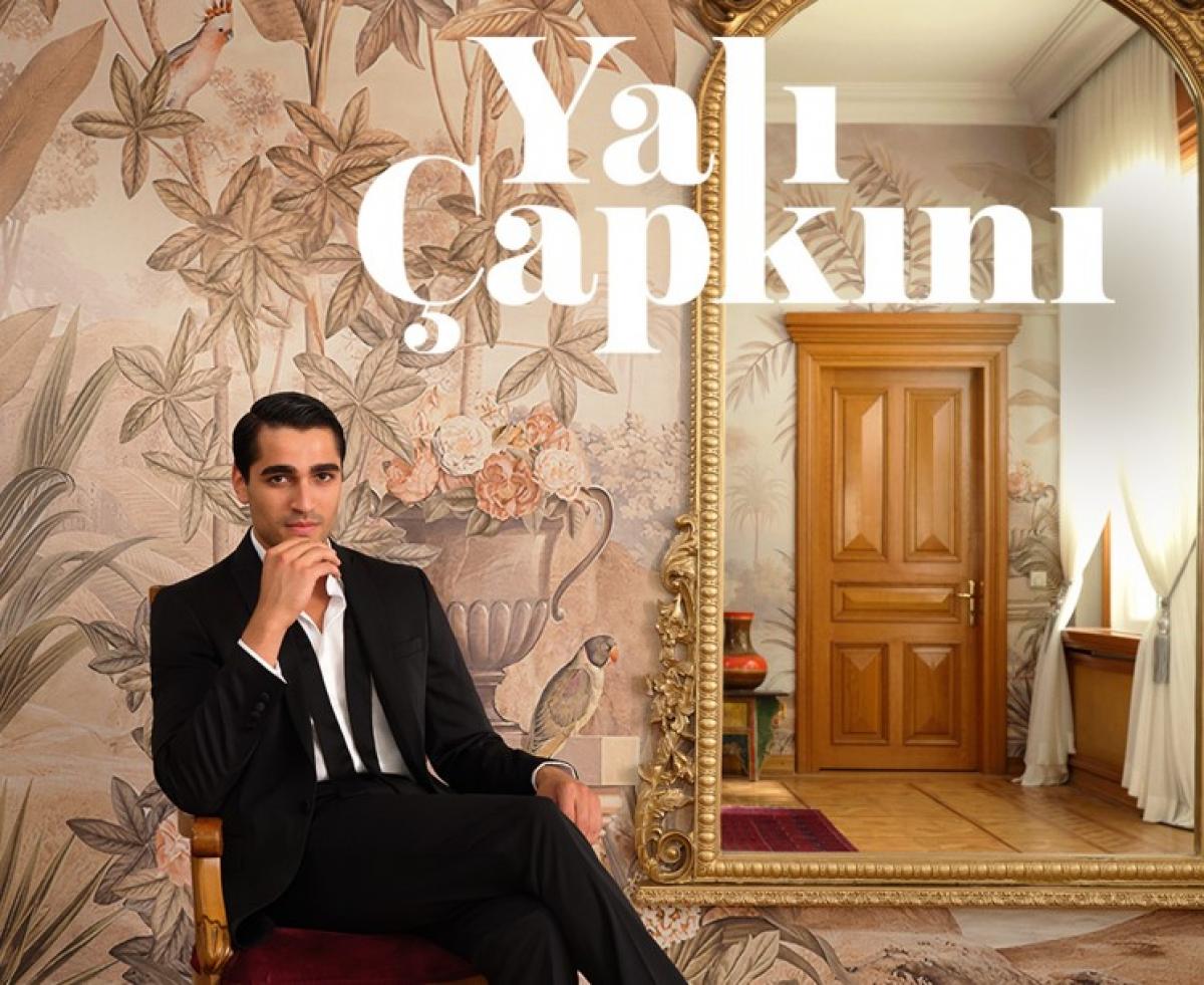 Mert Ramazan Demir poartă costum, cămașă albă și stă pe un scaun