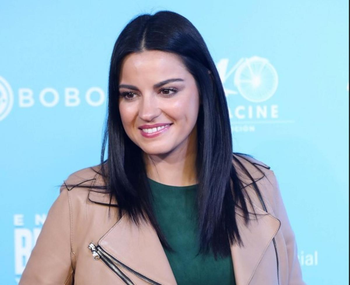 Maite Perroni poartă o bluză verde și o geacă de piele maro