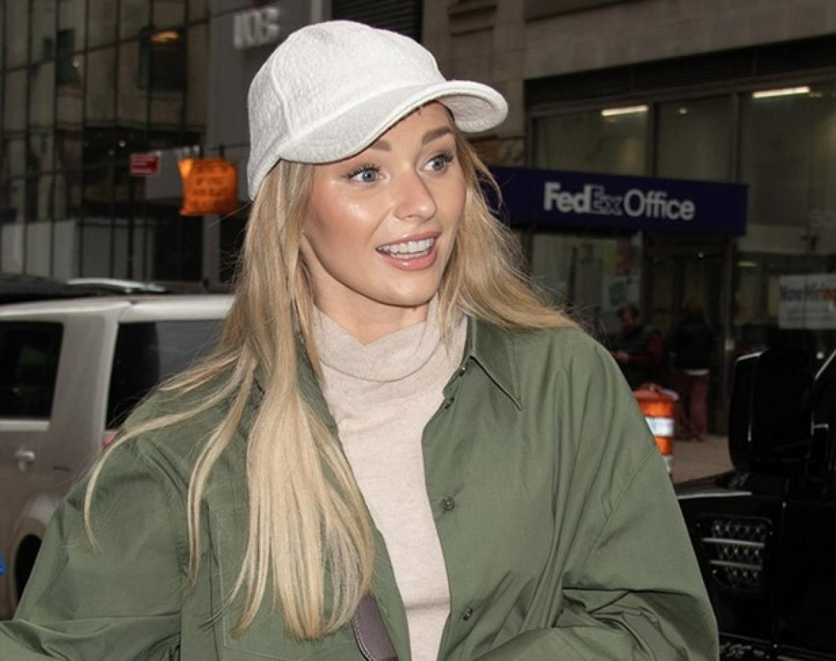 Irina Baeva poartă o salopetă verde închis și o șapcă deschisă la culoare