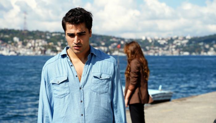Mert Ramazan Demir poartă o cămașă albastru închis cu mâneci lungi