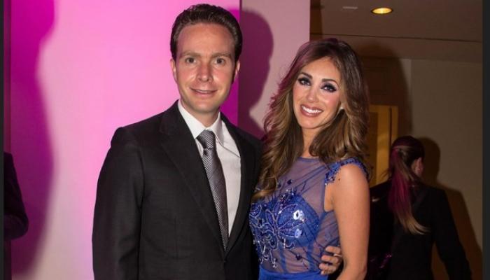 Anahi poartă o rochie albastră, lungă și zâmbește și stă lângă Manuel Velasco ce poartă un sacou