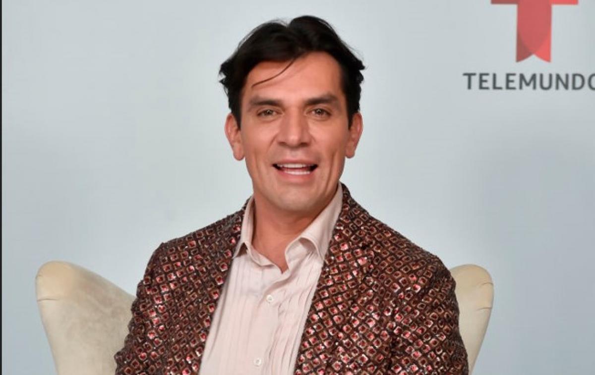 Jorge Salinas poartă o cămașă deschisă la culoare și un costum cu imprimeu