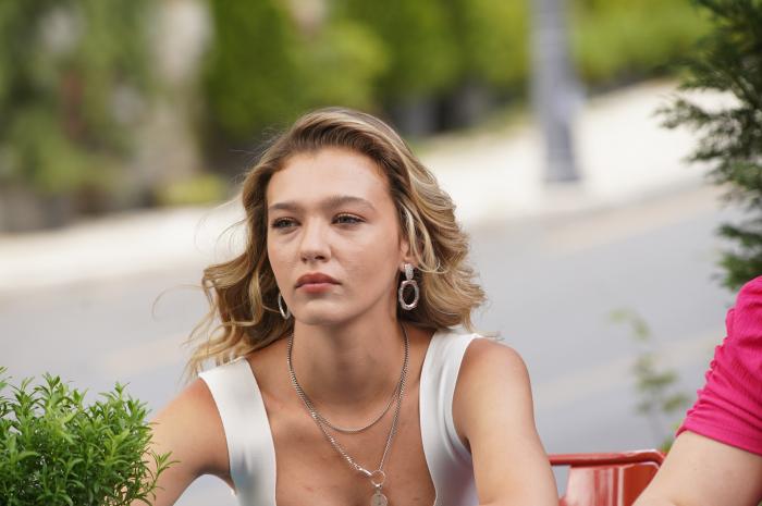 Melisa Döngel poartă o bluză fără mâneci și are părul desprins coafat pe spate