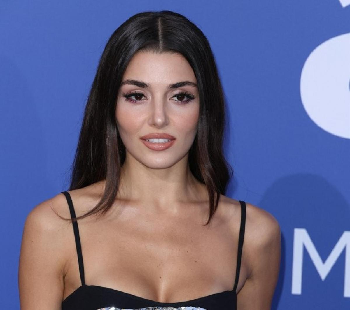 Hande Ercel poartă o rochie neagră fără mâneci și are părul desprins, pe spate