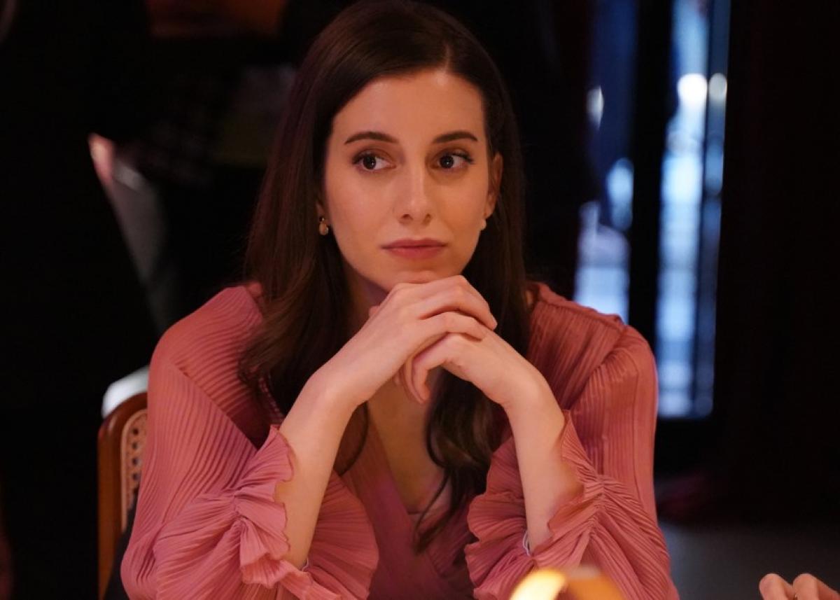 Beril Pozam poartă o rochie maro cu mâneci lungi