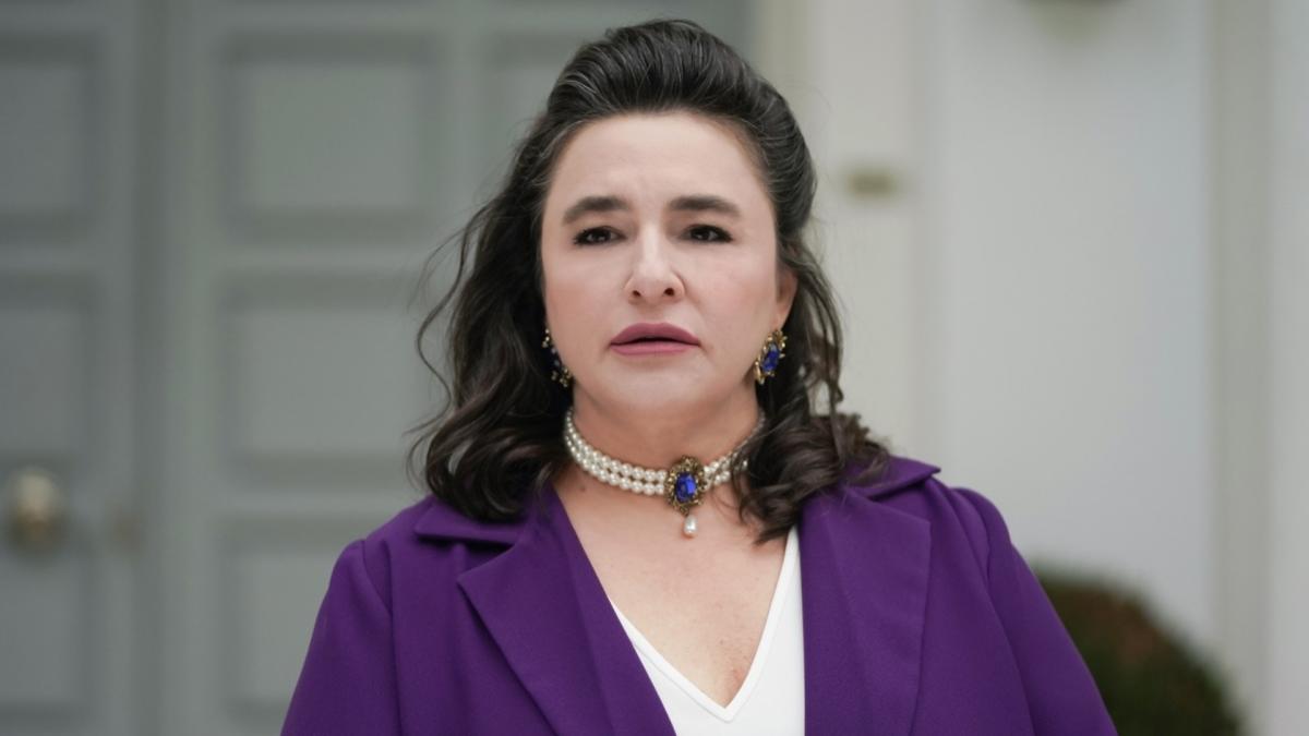 Esra Dermancıoğlu poartă o bluză albă și una mov și are părul desprins