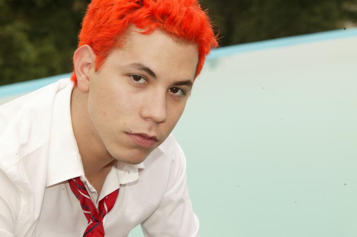 Christian Chávez poartă cămașă albă, cravată și părul roșcat