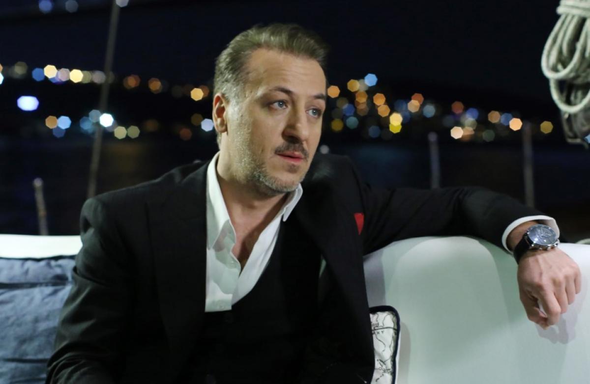 Barış Falay poartă o cămașă albă și un sacou negru