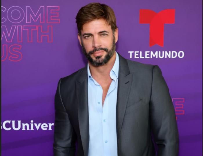 William Levy poartă o cămașă albastră pe un fundal mov cu roșu