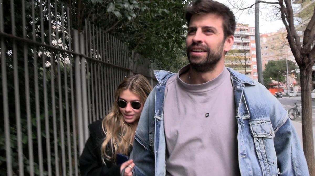 Gerard Piqué poartă o bluză și o geacă de blugi și merge alături de Clara Chia care poartă părul desprins și ochelari de soare