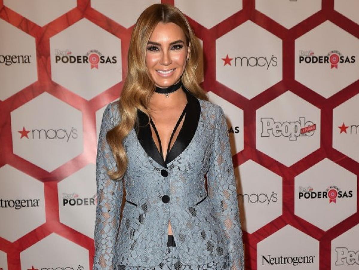 Elizabeth Gutiérrez poartă un costum cu mâneci lungi și zâmbește