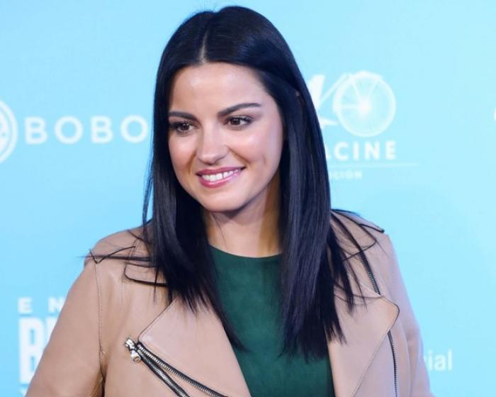 Maite Perroni poartă o bluză verde și o geacă de piele maro