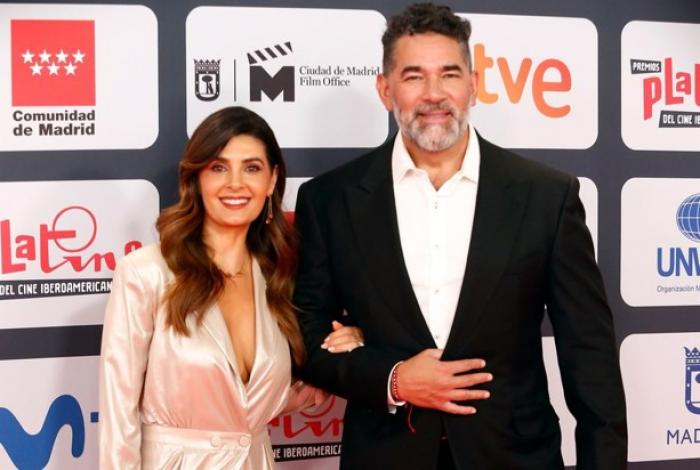 Mayrin Villanueva poartă o rochie cu decolteu și stă lângă Eduardo Santamarina care poartă un sacou negru și cămașă albă