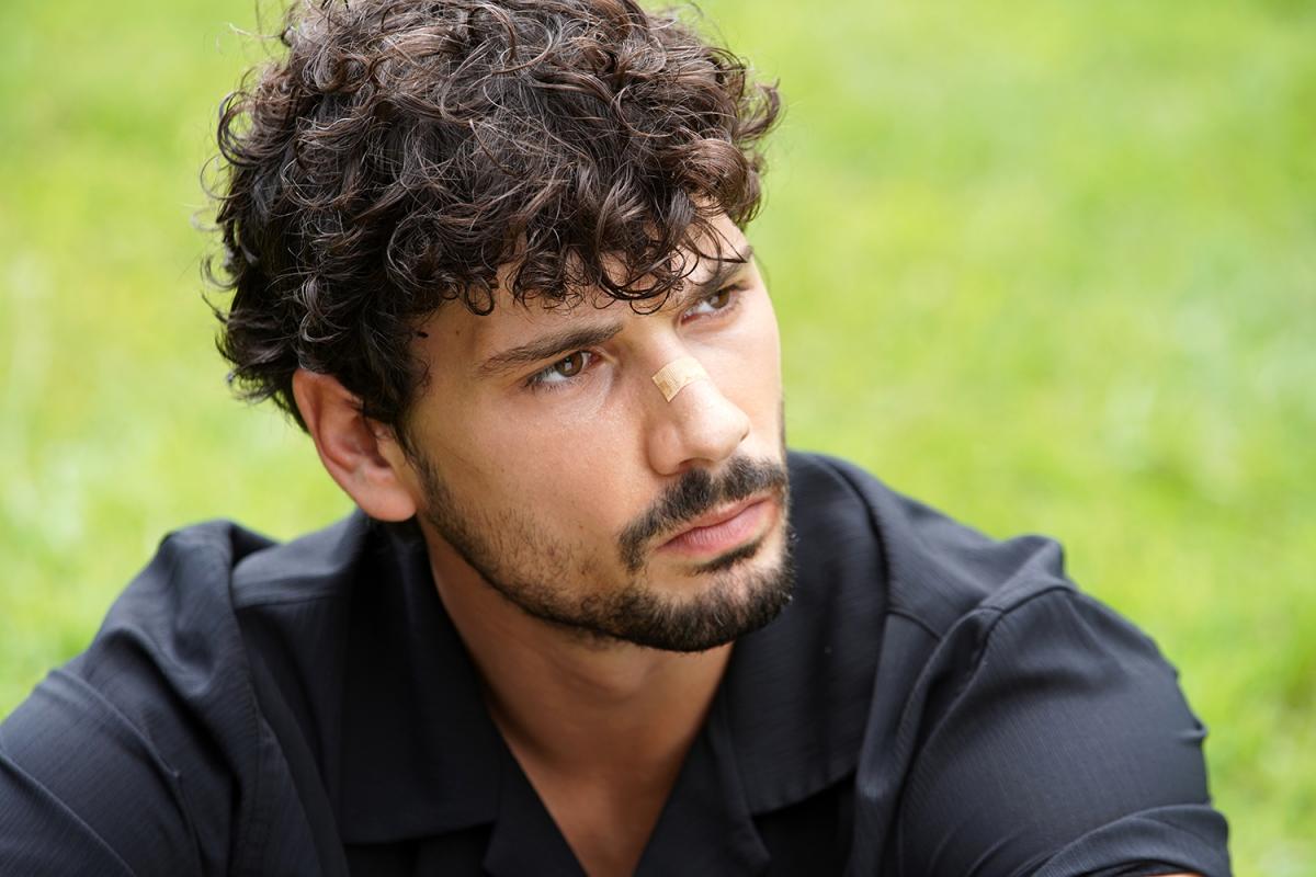 Deniz Can Aktaş poartă o cămașă neagră cu mâneci lungi