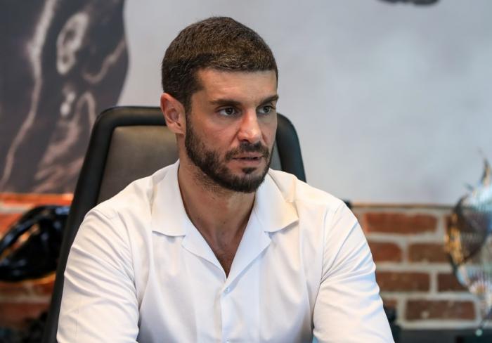 Berk Oktay poartă o cămașă albă cu mâneci lungi