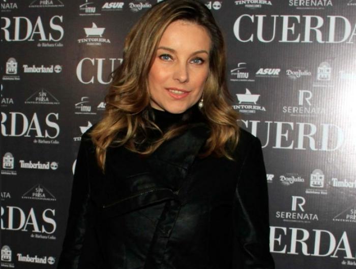 Dominika Paleta poartă o bluză neagră cu mâneci lungi și are părul lung desprins, ondulat