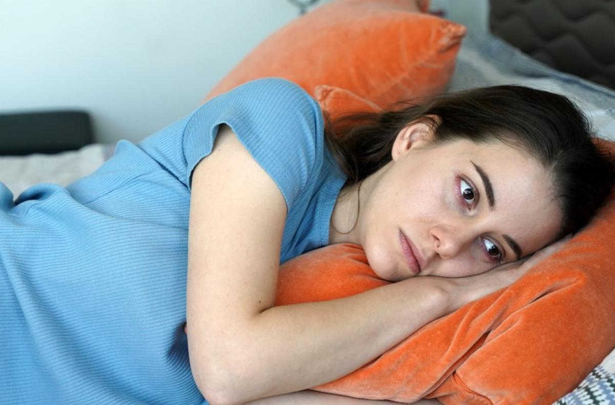 Beril Pozam poartă un tricou albastru și stă întins în pat cu mâinile sub cap