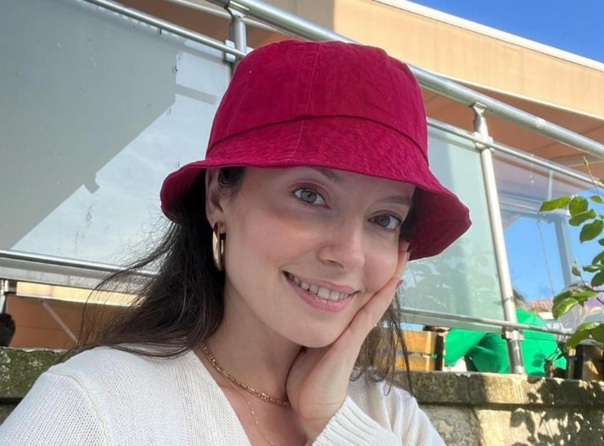 Gizem Arikan poartă o pălărie vișinie