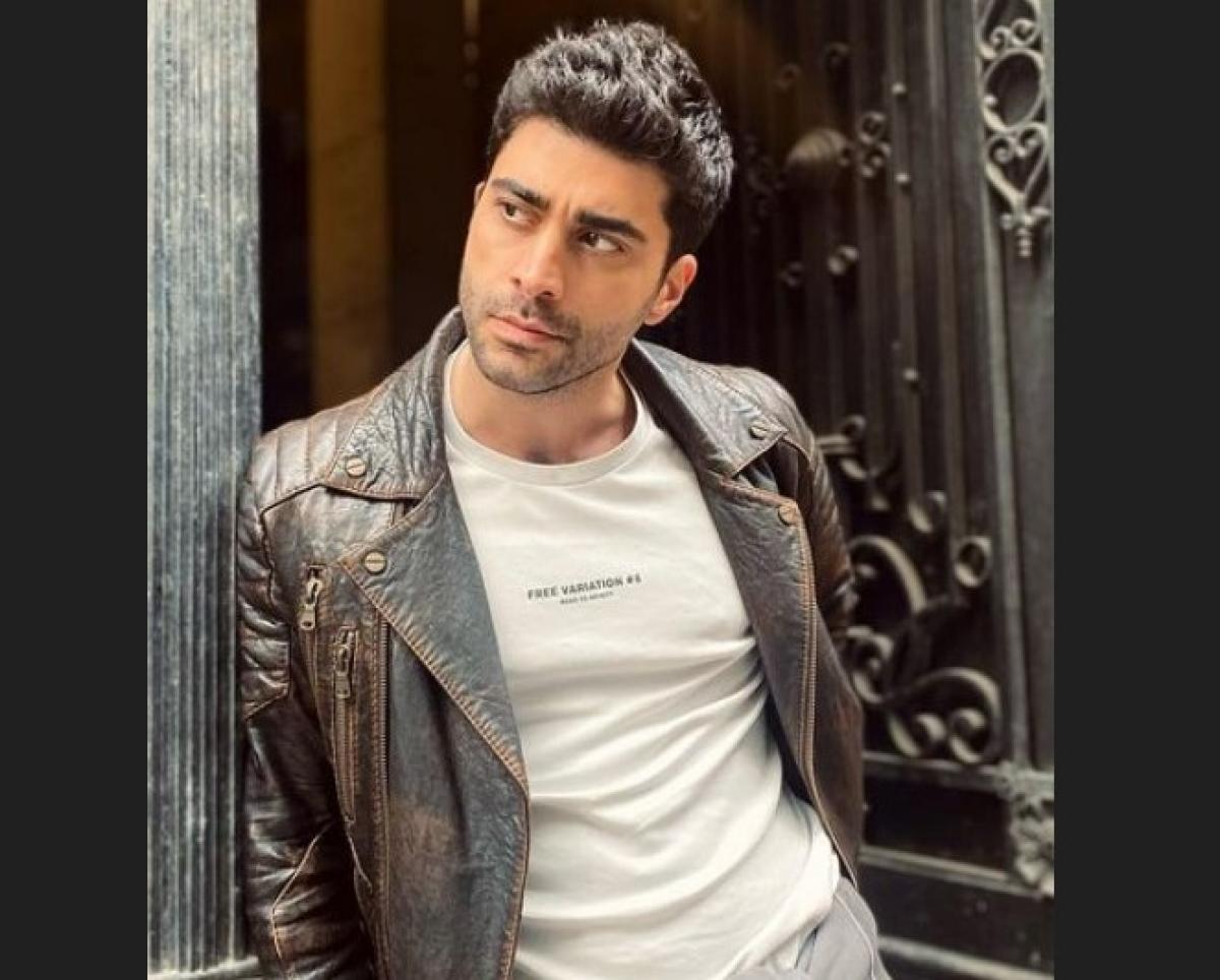 Dogukan Gungor poartă un tricou alb și o geacă de piele