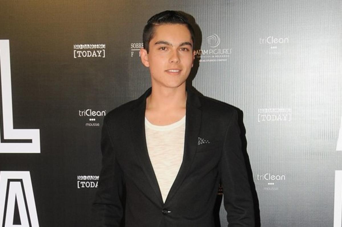 Sergio Mayer Mori poartă un tricou alb și un sacou negru și zâmbește