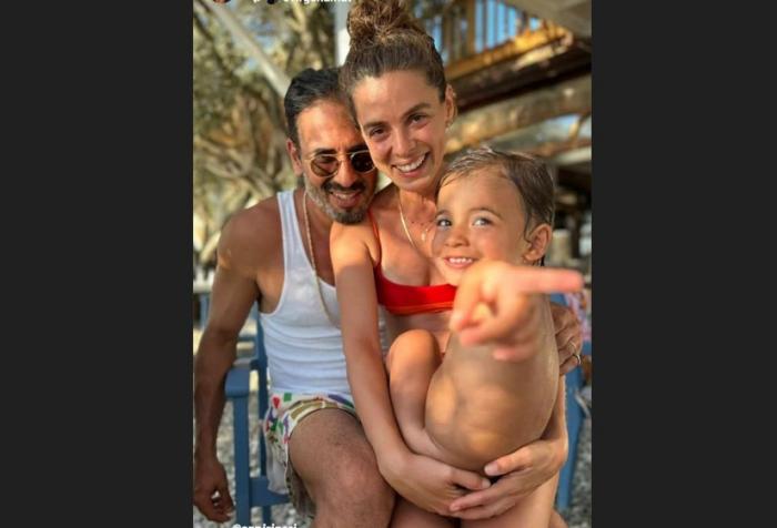 Ozge Özpirinçci poartă un costum de baie și își ține fiica în brațe