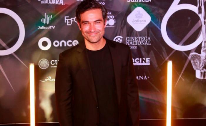 Alfonso Herrera poartă un costum negru și zâmbește pe covorul roșu