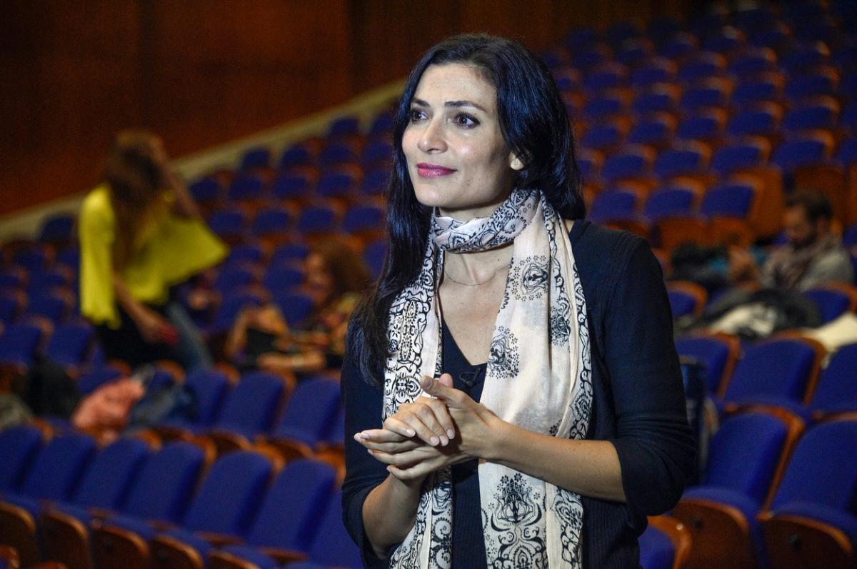 Ana María Orozco poartă o bluză închisă la culoare și o eșarfă