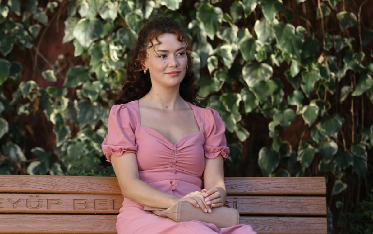 Seray Kaya poartă o rochie roz și părul lung, desprins, ondulat