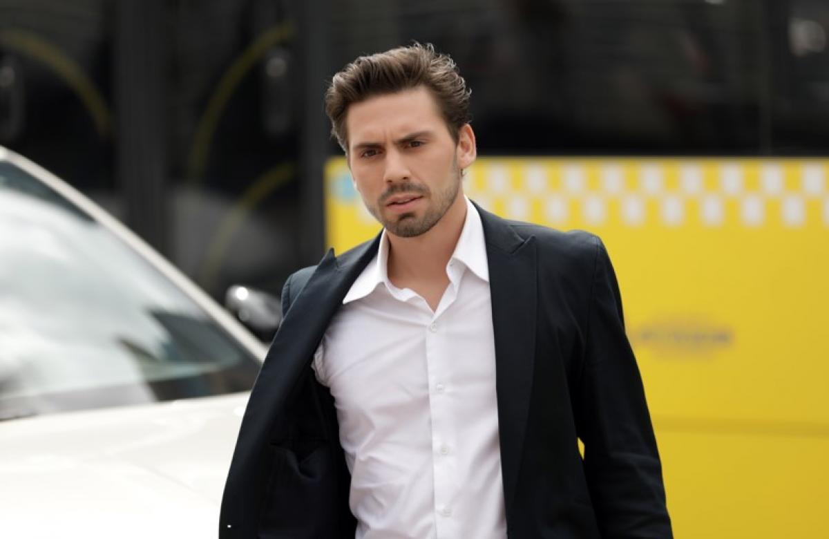 actor poartă o cămașă albă și un sacou negru