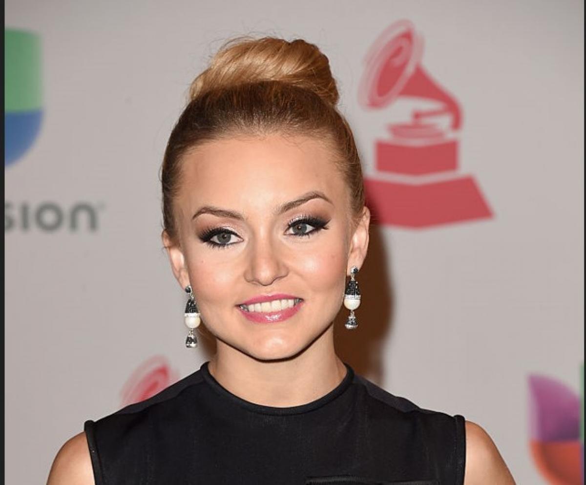 Angelique Boyer poartă o rochie neagră fără mâneci și are părul prins în coc