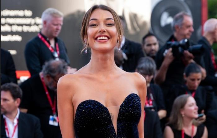 Dilan Cicek Deniz poartă o rochie neagră fără mâneci și zâmbește