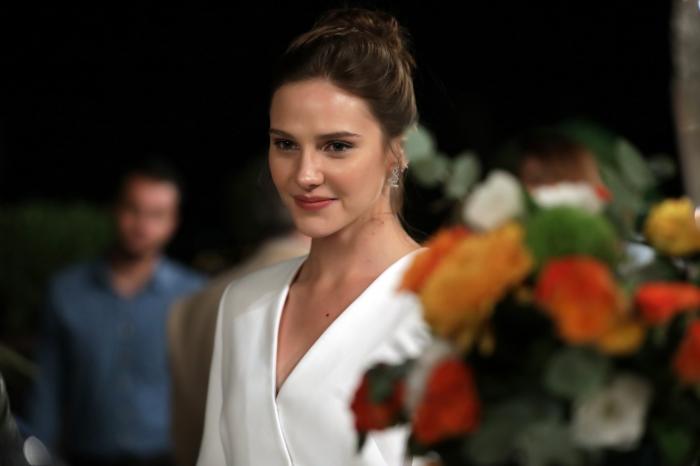 actrița poartă o rochie albă și zâmbește