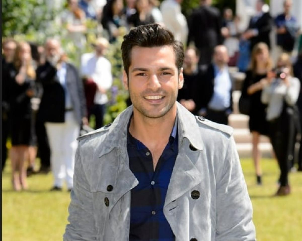 actor poartă un palton gri