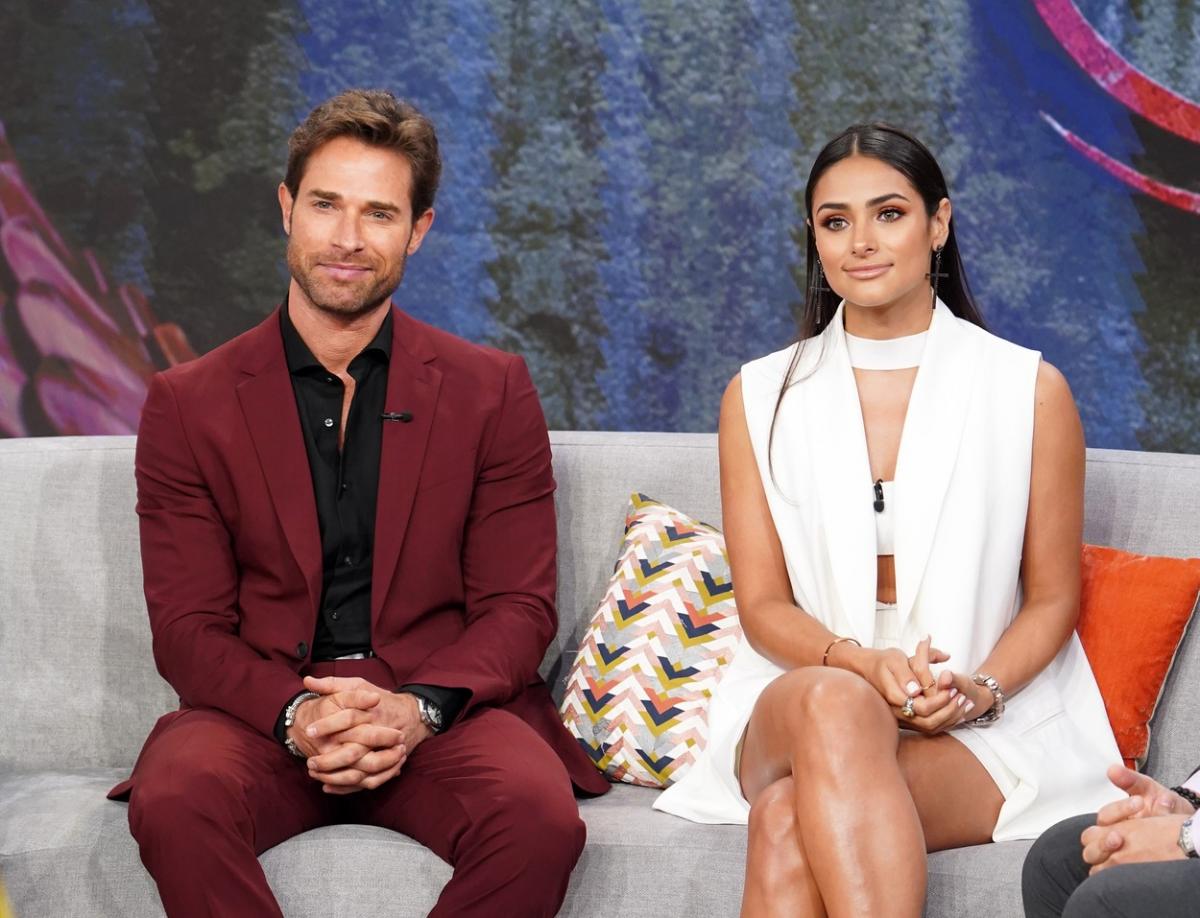 actor poartă un costum vișiniu și actrița poartă o rochie albă