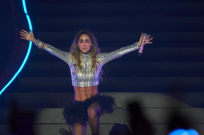 actrița poartă un top scurt și o fustă neagră