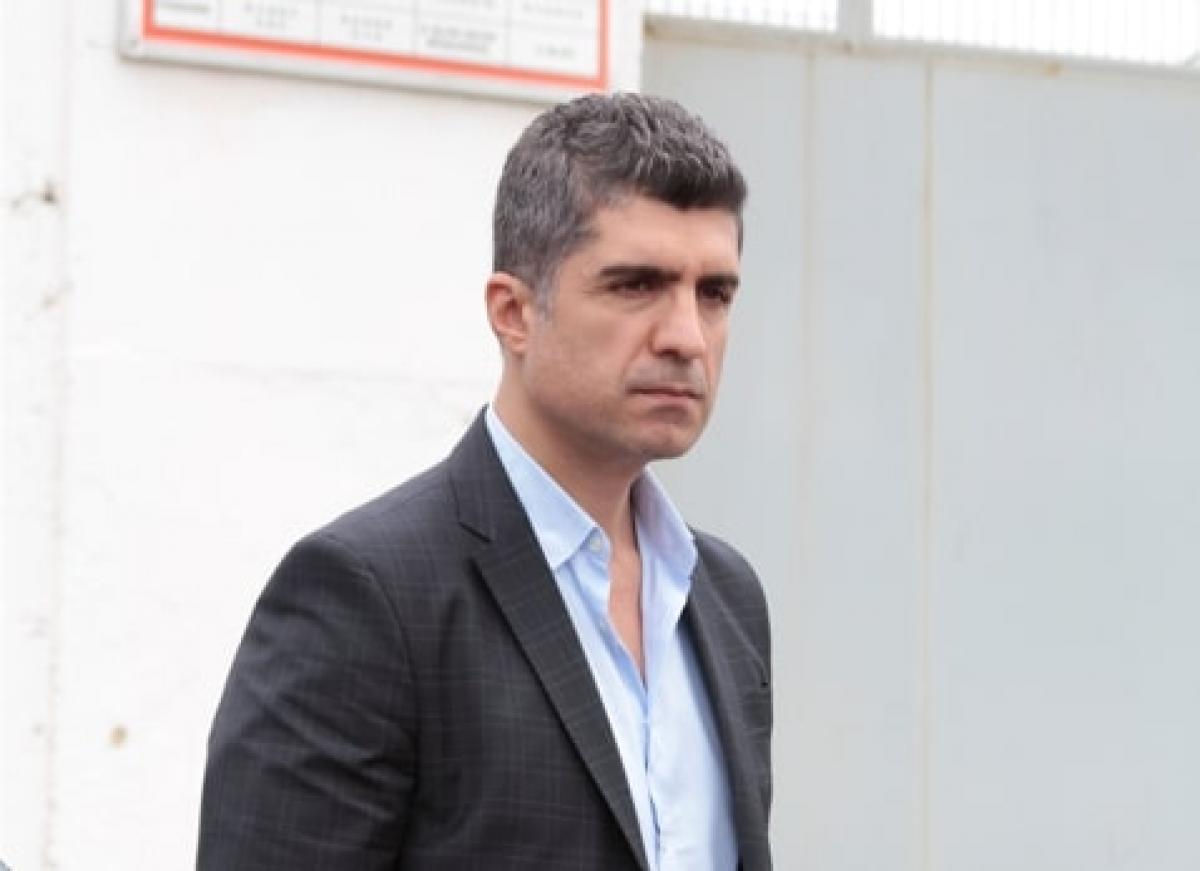 actor poartă o cămașă deschisă la culoare și un sacou negru