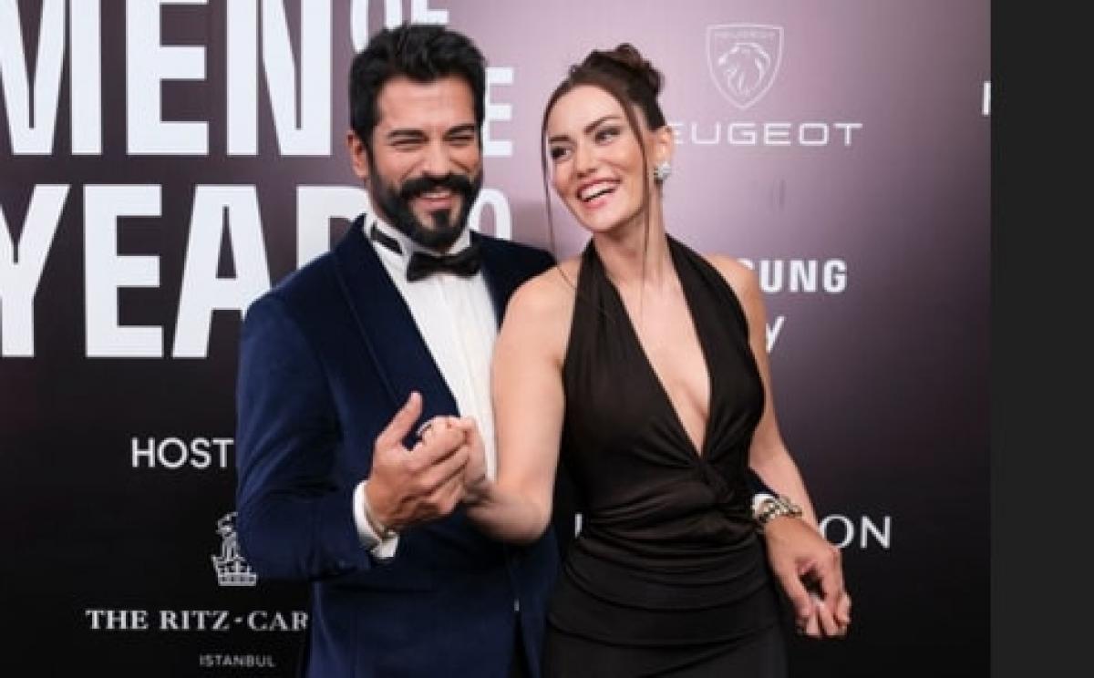 actori care stau îmbrățișați și zâmbesc